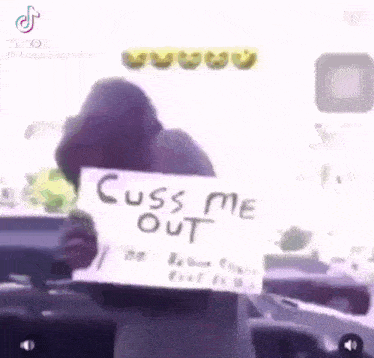 a person is holding a sign that says `` cuss me out '' .