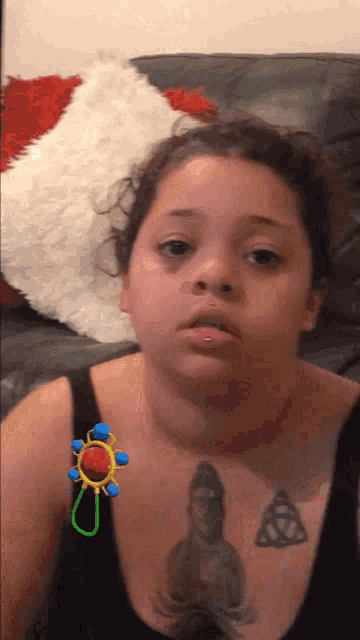 a woman with a tattoo on her chest has a baby rattle on her shoulder