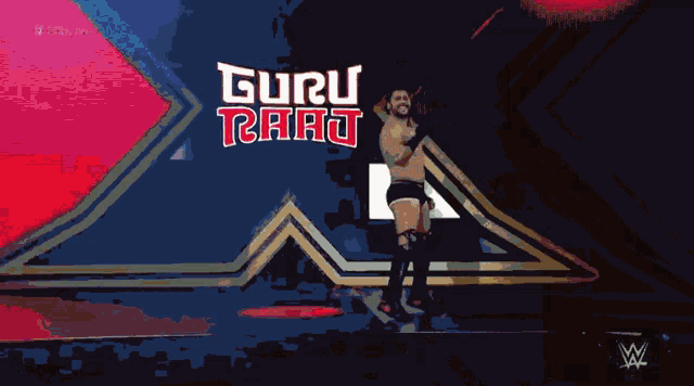 a wrestler is standing in front of a sign that says guru rath
