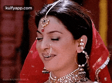 a close up of a woman wearing a nose ring , earrings , and a veil .