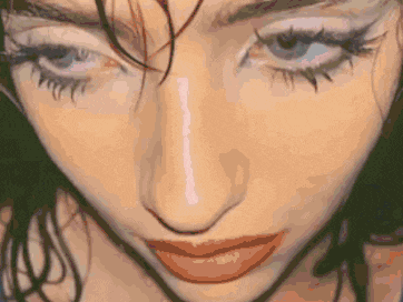 a close up of a woman 's face with a lot of makeup on it .