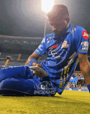 a man laying on the grass with a jio logo on his arm