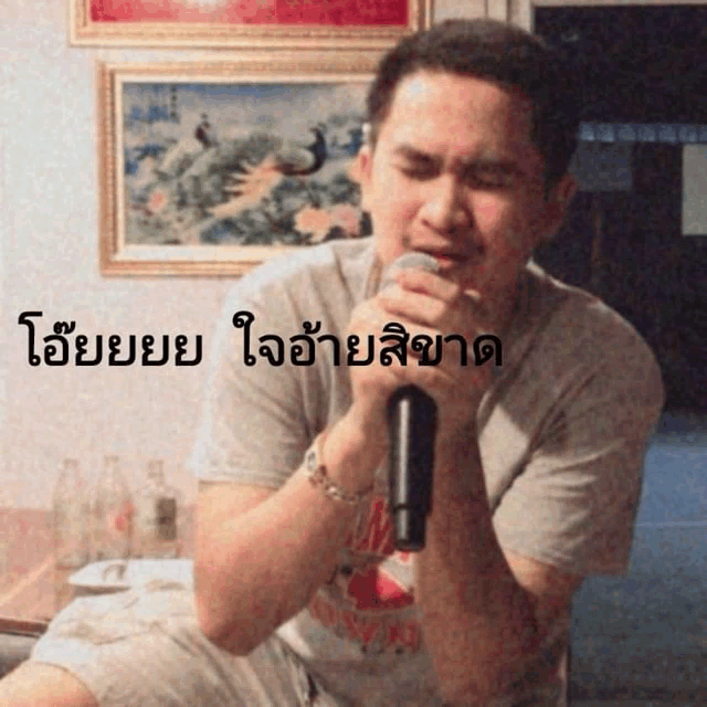 a man singing into a microphone with a foreign language caption