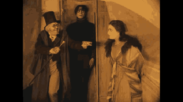 a man in a top hat is standing next to two women