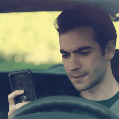 a man in a car looking at his phone