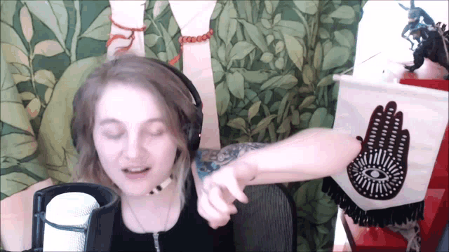 a woman with a tattoo on her arm is wearing headphones and holding her arm up