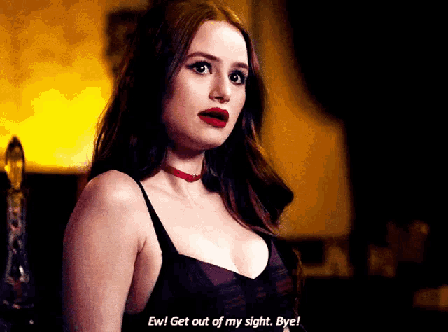 a woman in a black bra and red choker is talking to someone .