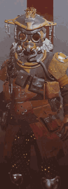 a man wearing a gas mask and goggles stands in front of a red wall