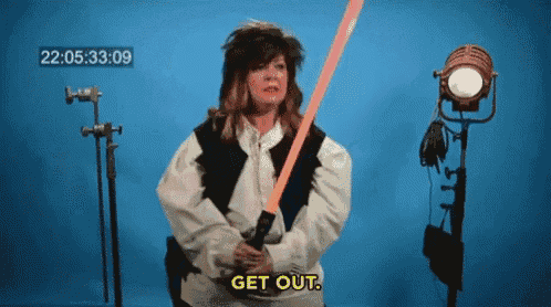 a woman in a star wars costume is holding a light saber and saying get out