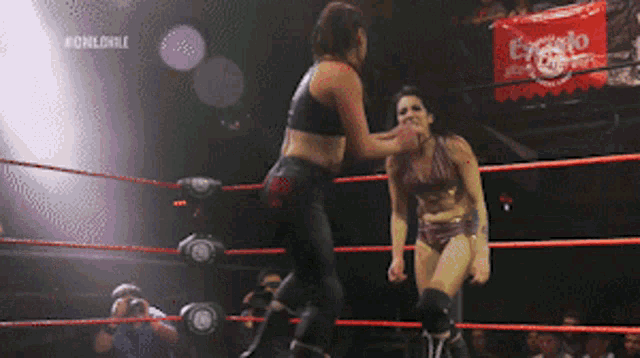 two women are wrestling in a ring with a sign that says #chileonle in the background