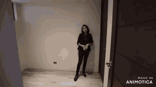 a woman standing in an empty room with the words made in animotica on the bottom