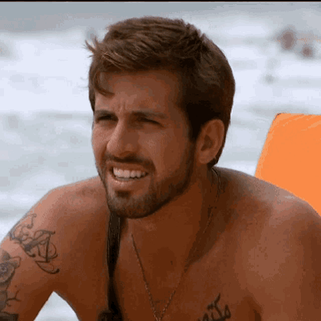 a shirtless man has a tattoo on his chest that says ' a '