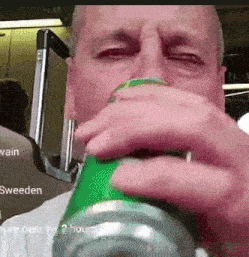 a man is drinking from a green can with sweden written on the bottom