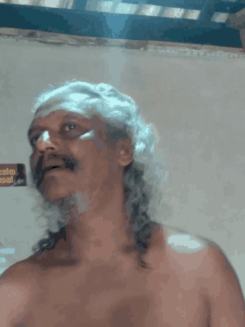 a shirtless man stands in front of a sign that says ' kerala '