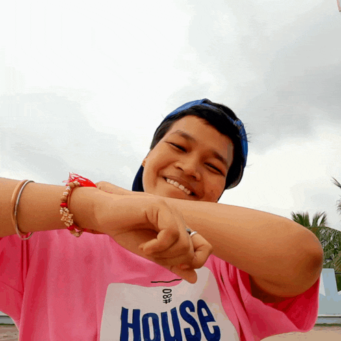 a woman wearing a pink shirt that says house on it