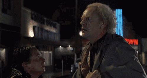 a man with a surprised look on his face is standing in front of a sign that says " great scott "