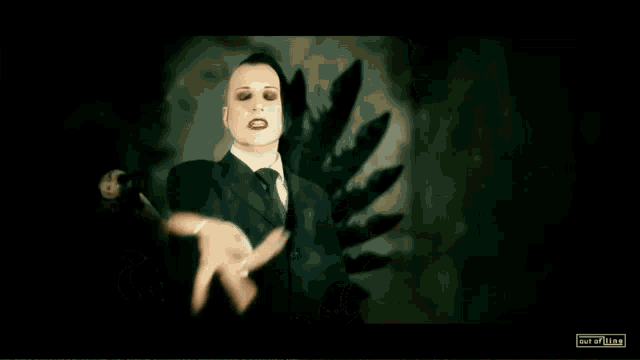 a man in a suit and tie is reaching out towards the camera with the words out of line below him