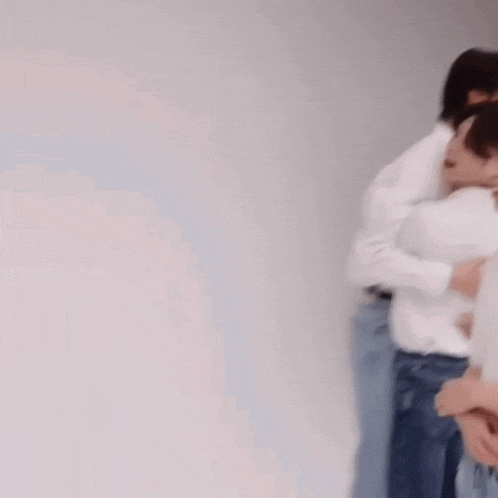 a group of people are hugging each other in a room .