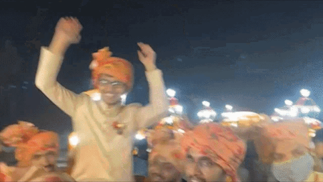 a group of men wearing turbans are dancing in a dark room