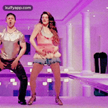 a man and a woman are dancing together in a room with purple walls .