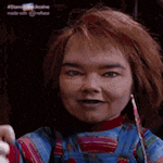 a doll with red hair is wearing overalls and a striped shirt .