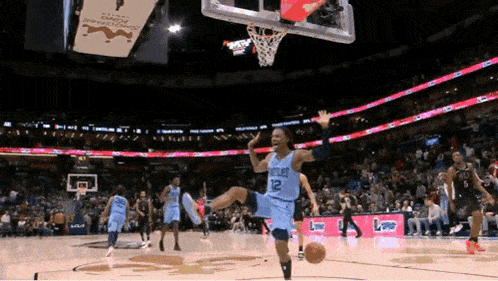 a basketball player wearing a number 12 jersey is jumping in the air