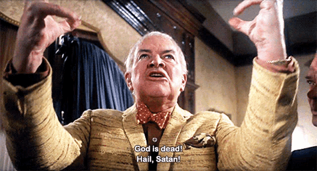 a man in a suit and bow tie is saying god is dead