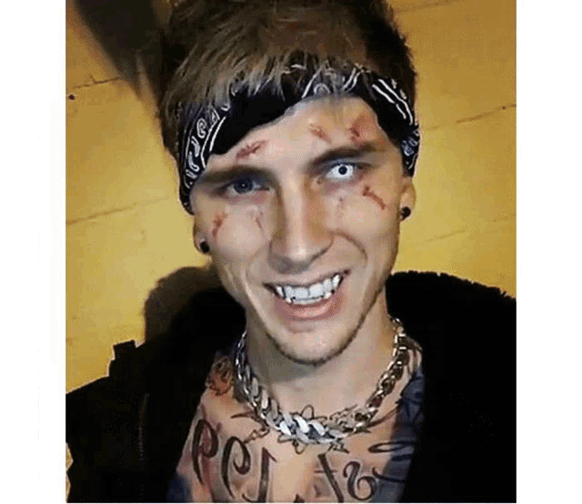 a man with a bandana on his head and a necklace on his neck is smiling .