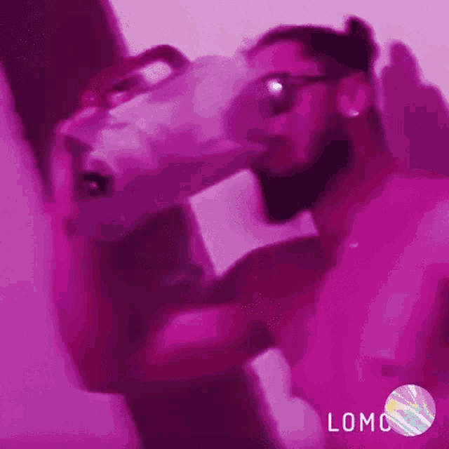 a man without a shirt is holding a bag in his hand in a purple room .
