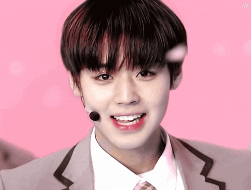 a young man wearing a suit and tie is smiling
