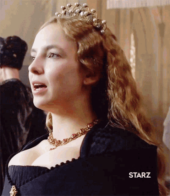 a woman wearing a tiara and a starz logo on her chest