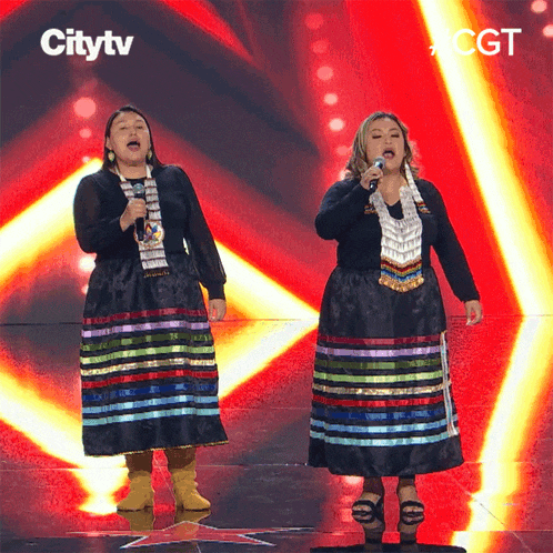two women singing on a stage with a citytv logo in the background