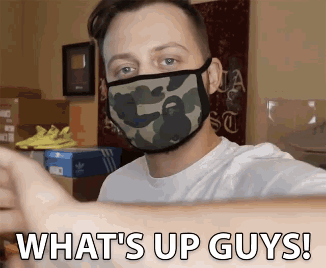 a man wearing a camouflage mask says what 's up guys