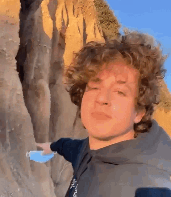 a young man with curly hair is wearing a blue mask