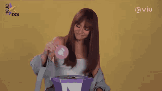 a woman is putting a pink thumbs down sign into a box