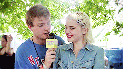 a man wearing a blue shirt that says new york is holding a microphone next to a woman