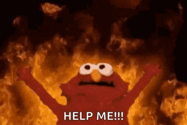 elmo from sesame street is standing in front of a wall of fire .