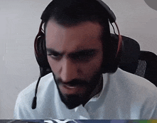 a man with a beard wears headphones and a microphone