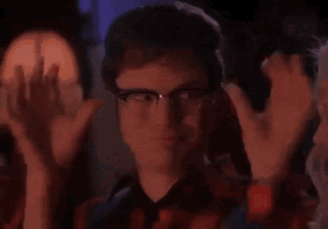 a man wearing glasses and headphones is making a funny face .