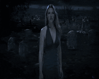 a woman in a black dress stands in front of a blue background