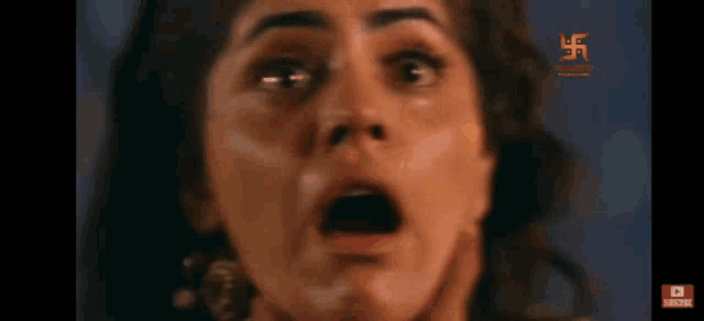 a close up of a woman 's face with a cross in the corner