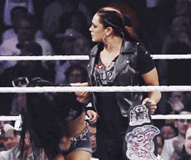 two women in a boxing ring with one wearing a shirt that says rude