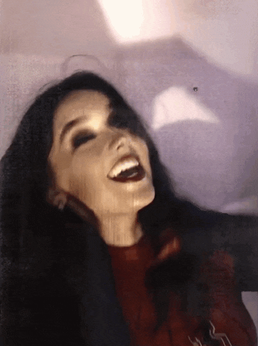 a woman with long dark hair is smiling and looking at the camera
