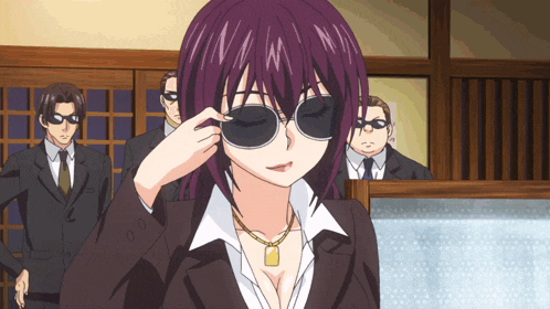 a woman wearing sunglasses and a necklace stands in front of a group of men in suits