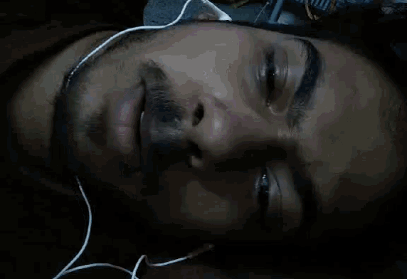 a close up of a man 's face with earbuds on
