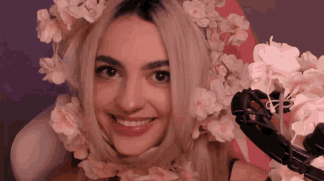 a woman wearing flowers on her head is smiling