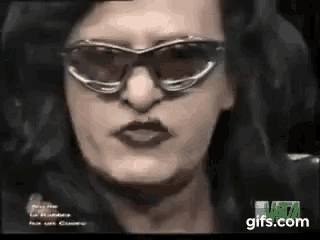 a close up of a woman 's face wearing sunglasses and a black jacket .