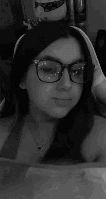 a black and white photo of a woman wearing glasses and a headband