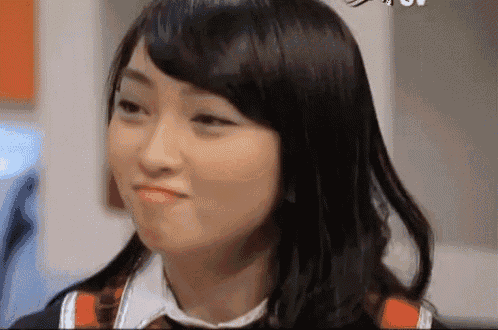a woman with long black hair is making a funny face