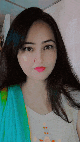 a woman with a nose ring is wearing a white shirt and a blue scarf